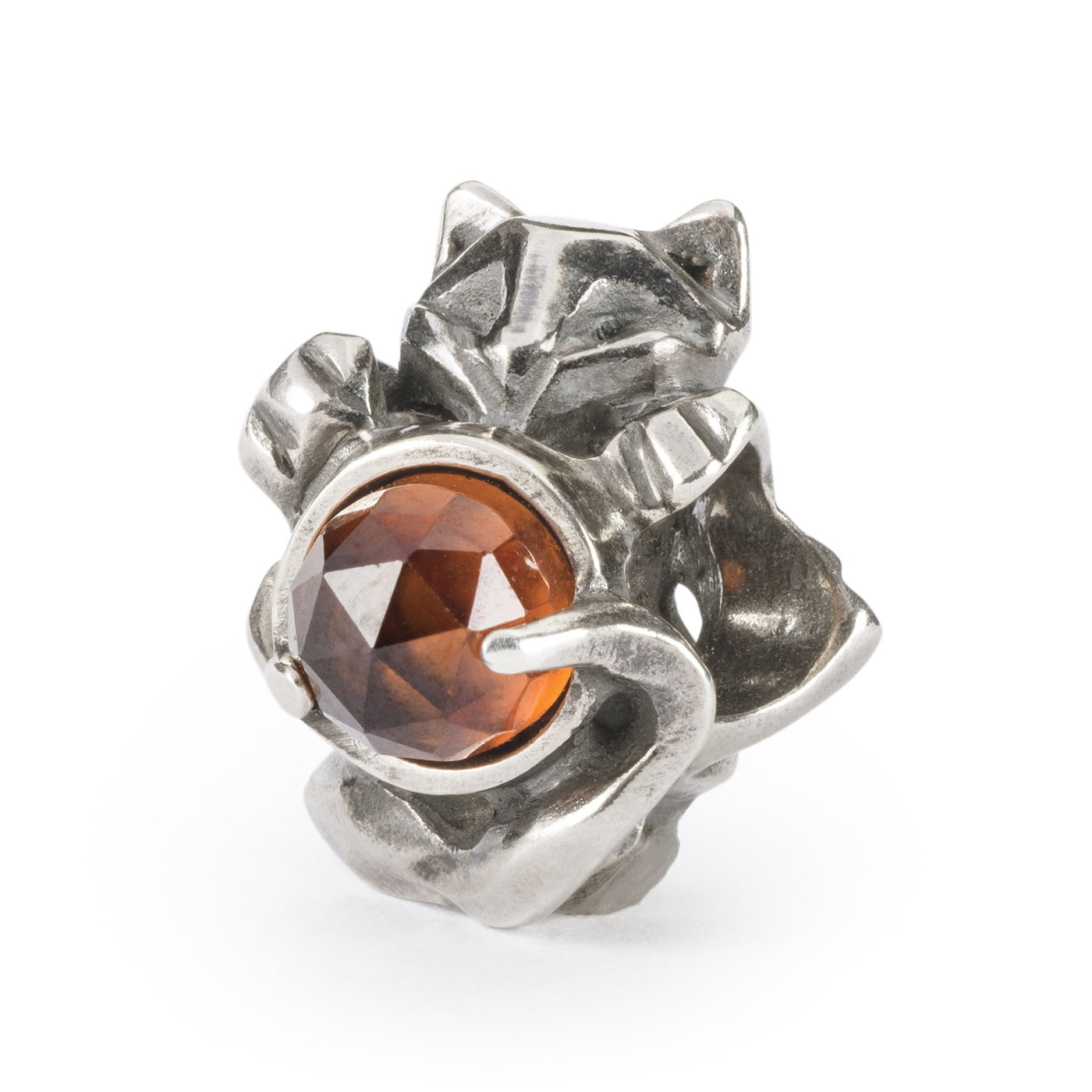 A silver jewellery cat bead playing with a Hessonite stone.